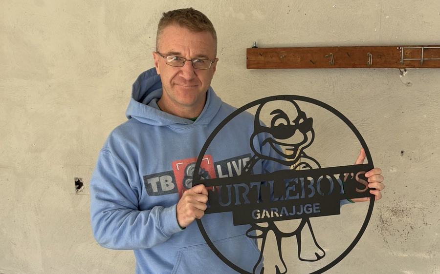 The Market client celebrating at his new home with a custom Turtleboy's Garage sign