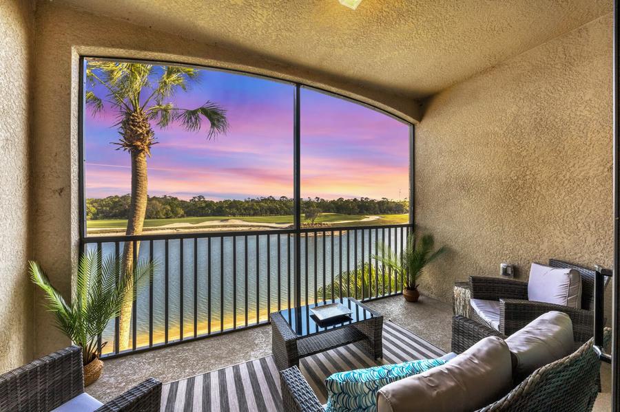 Florida balcony overlooking a waterfront and golf course at sunset